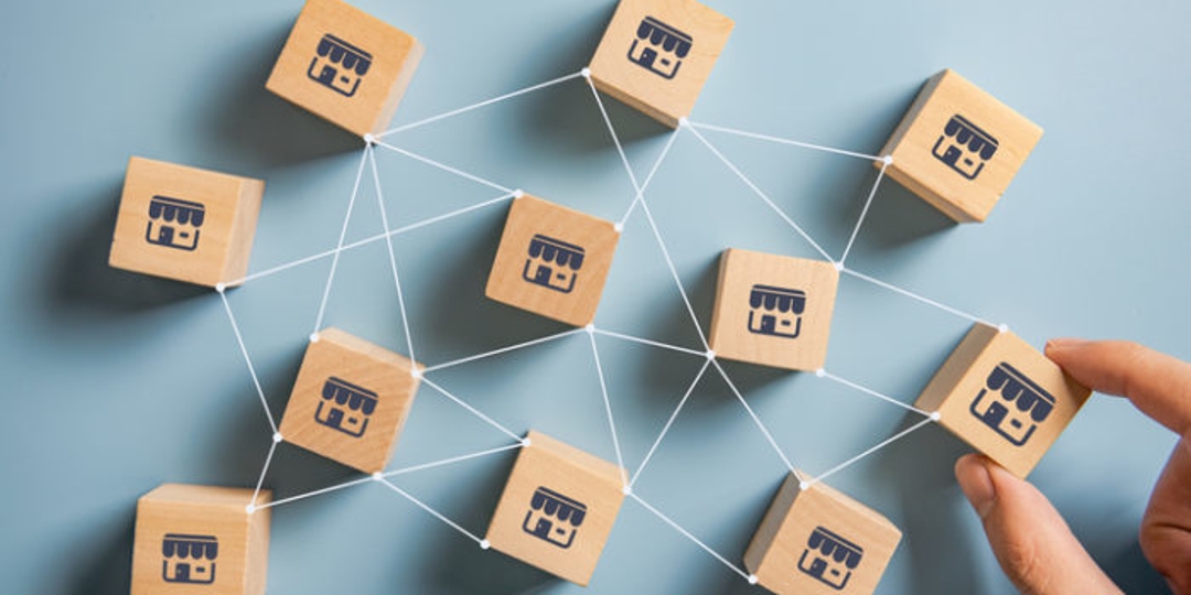 Wooden Blocks with Stores on them being moved around by hands