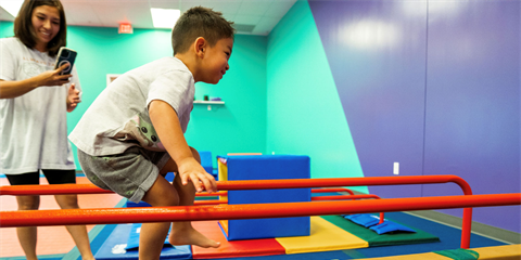 mom taking photo of child on balance beam