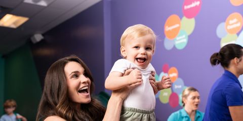 woman holding baby inside gym